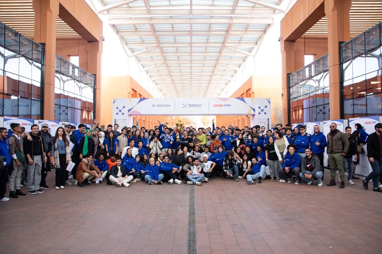 Group photograph at X-Ibition event in a university atrium